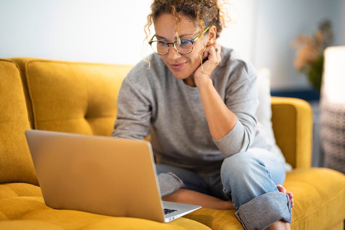 Frau auf Sofa mit Laptop - Bewerbungsprozess auf Recruiting-Landingpage